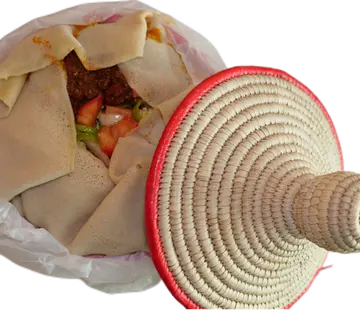 Food served in a traditional woven basket with a lid.