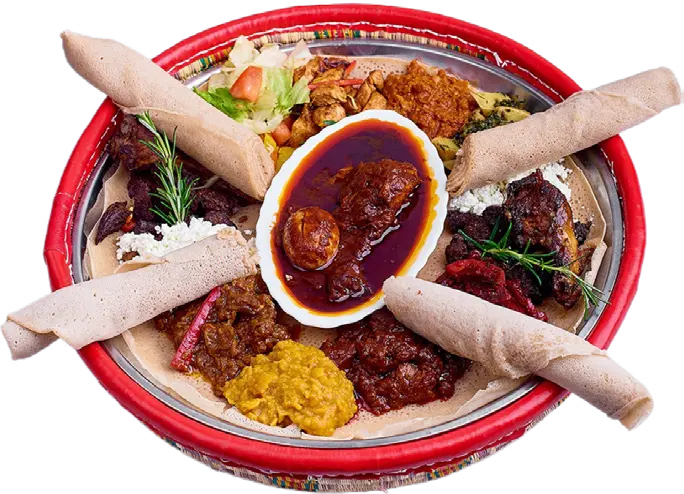 A sharing platter with meat dishes, vegetables and injera rolls.