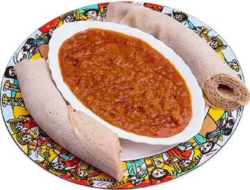 Misir Wot in a bowl on a plate with injera.