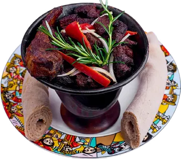 Shekla Tibs in a heated serving dish with peppers and rosemary.