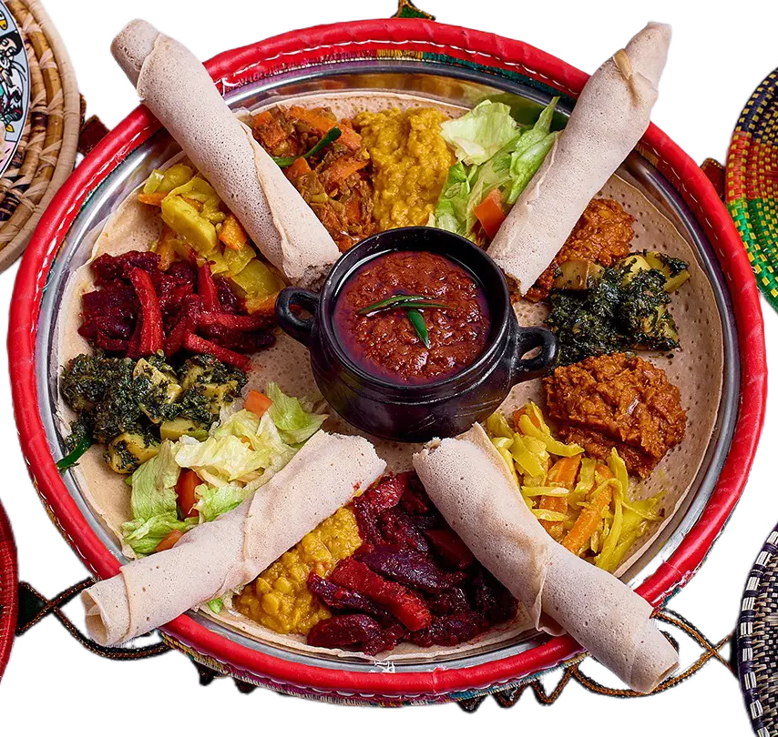 A sharing platter of colourful vegan dishes and rolled injera in a woven basket.