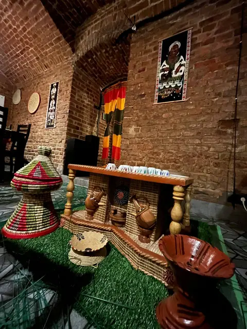The coffee ceremony corner: clay jebena pots, woven baskets and striped cloth.
