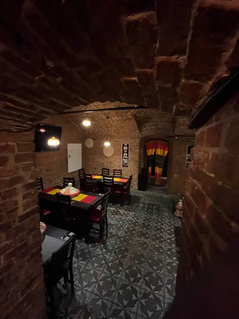 The second vaulted room, its doorway hung with cloth in the colours of the flag.
